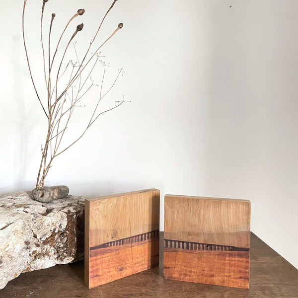 Contemporary abstracted landscape art grounded in natural wood bringing biophillic warmth and calm to considered interiors 